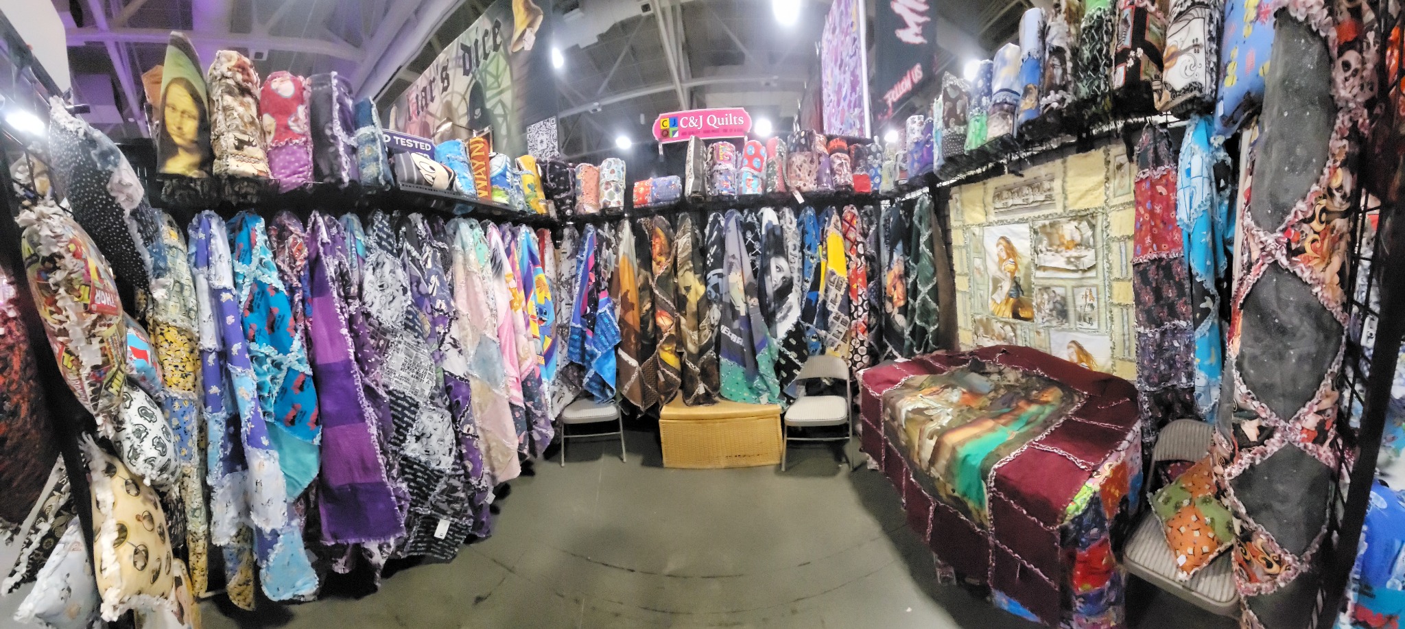 Inside CJ’s booth, surrounded by colorful hanging rag quilts