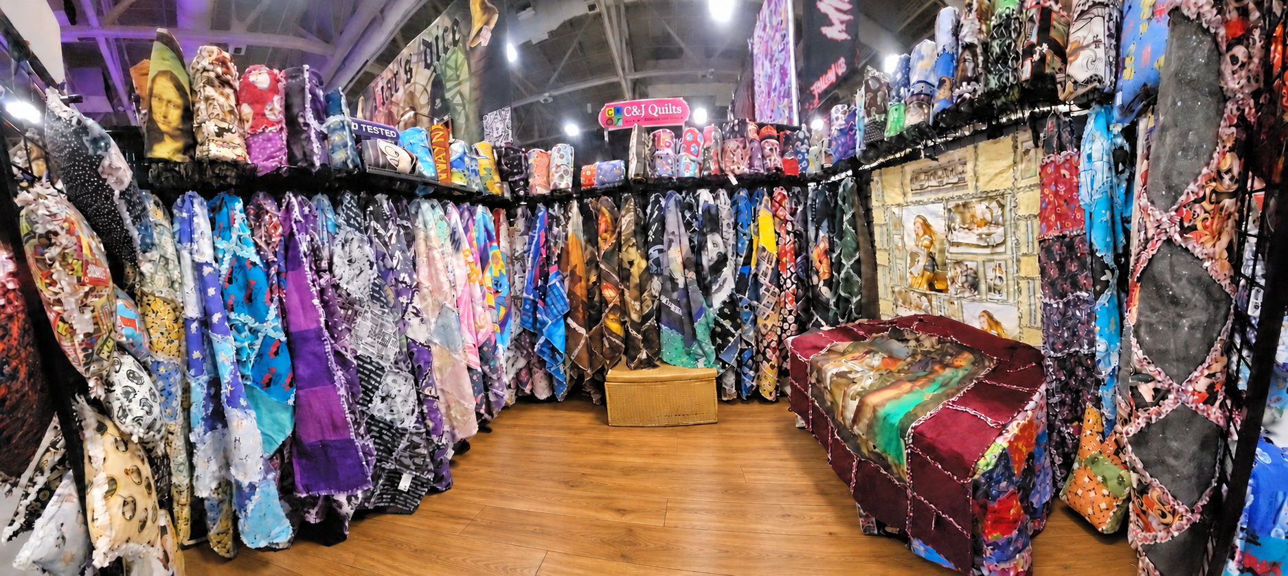 Inside CJ’s booth, surrounded by colorful hanging rag quilts